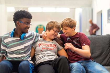 Tre børn i en sofa på Stensagerskolen